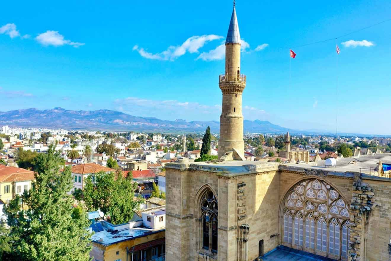 A city with a mosque and mountains in the background.