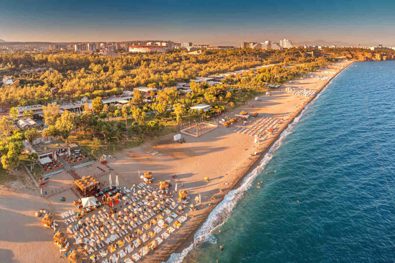 An aerial view of a beach with chairs and umbrellas.