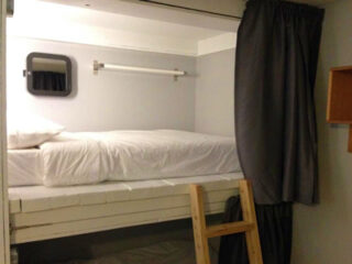 A small room with two bunk beds and a ladder.