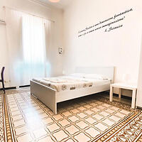A bedroom with a bed and a tiled floor.