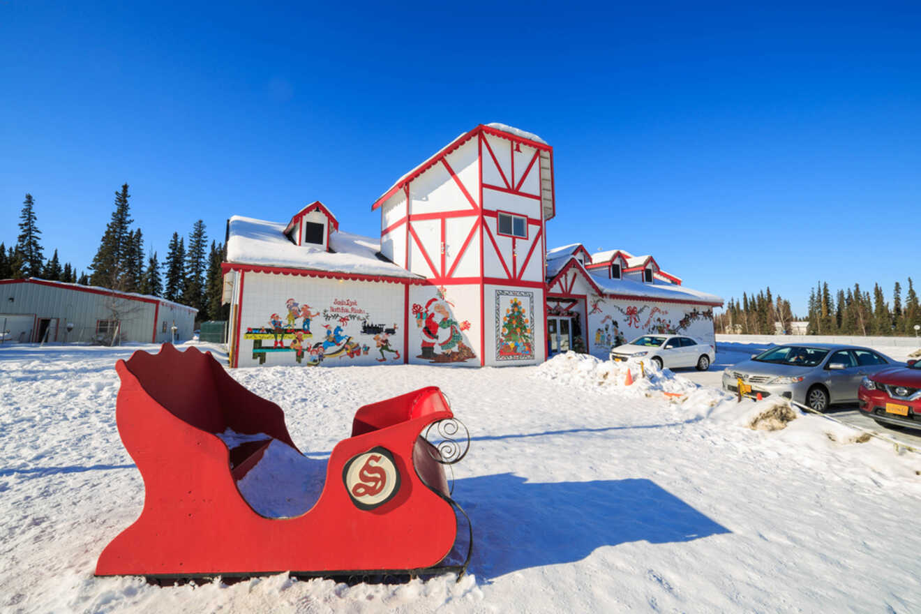 a sleigh on the snow in front of a Santa Claus house