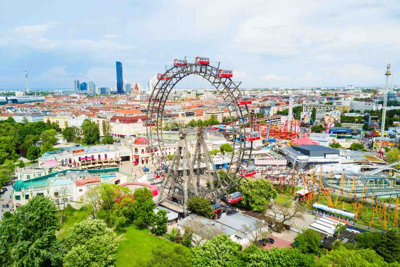 An aerial view of an amusement park with a ferris wheel in the background.