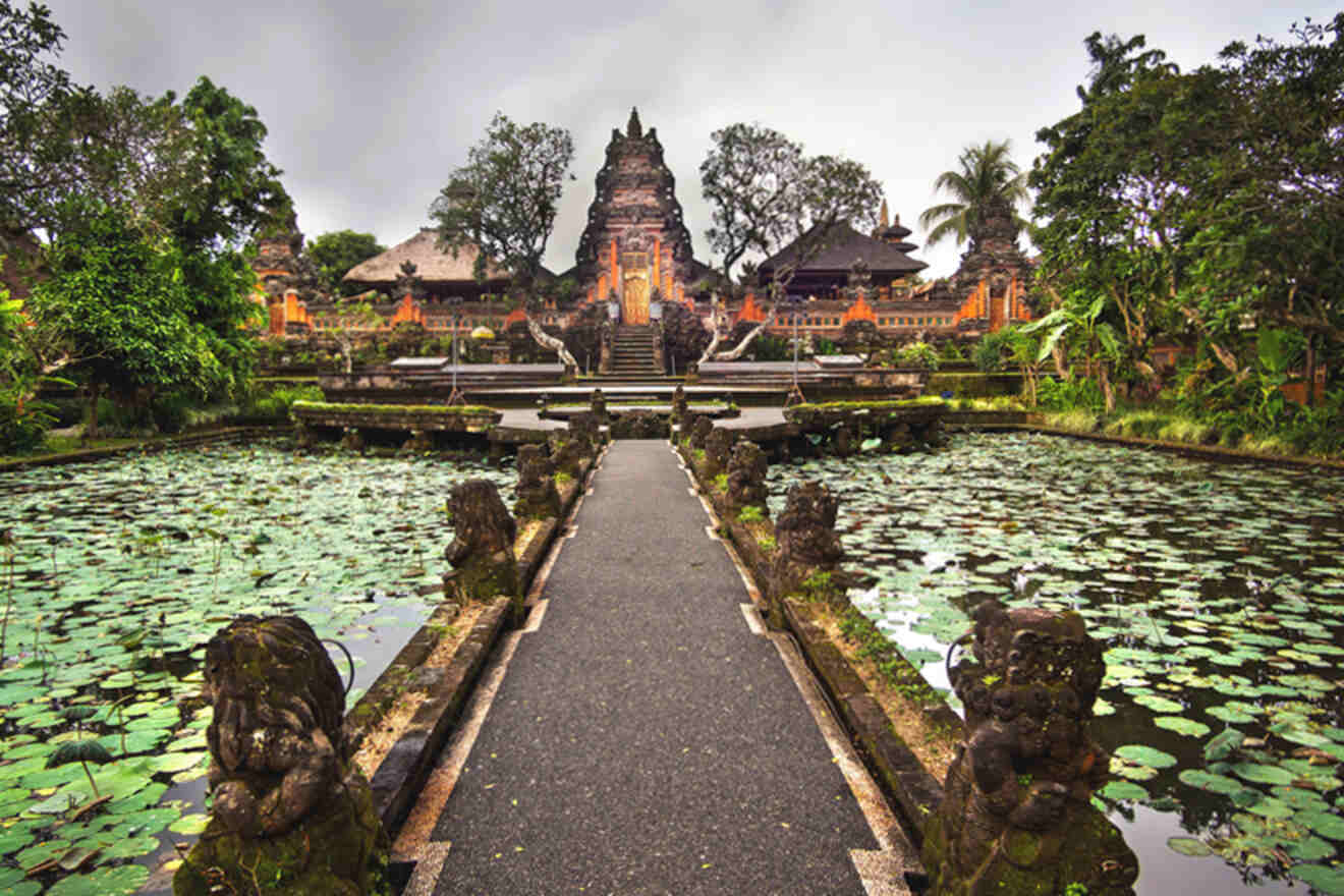 A temple with statues and water lilies in the background.
