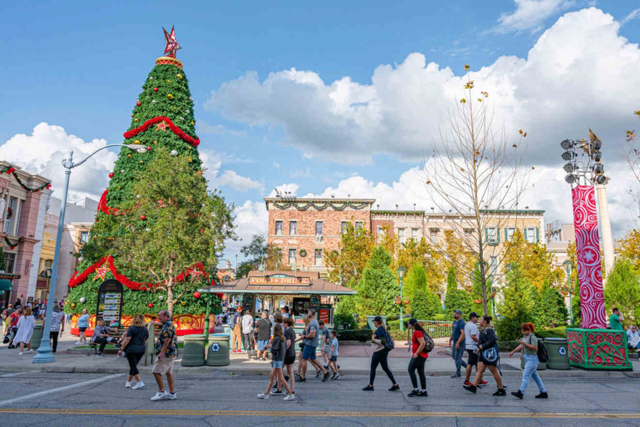 people walking on a street near a Christmas tree during the day