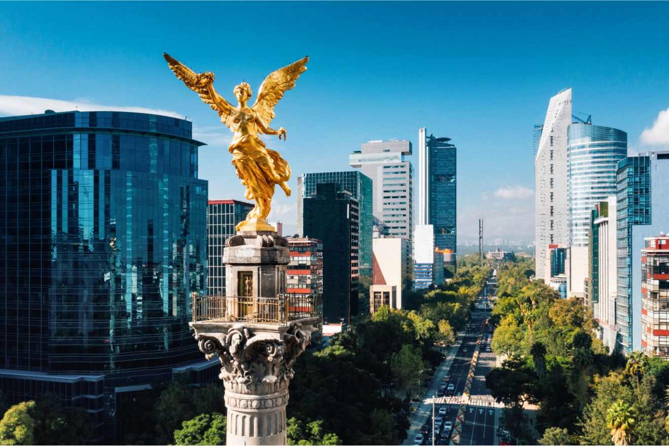 A statue of an angel in Mexico City with a street with tall buildings in the background