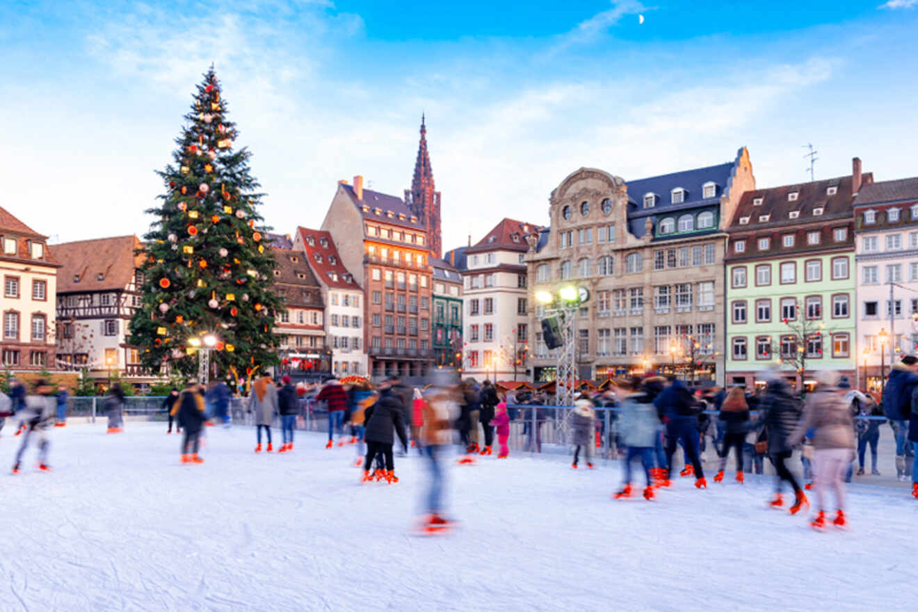 people ice skating next to a tall Christmas tree