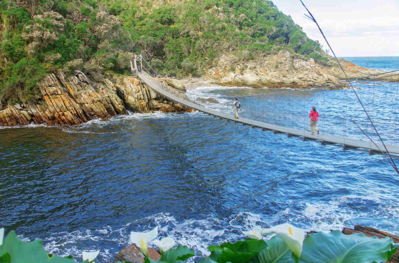 a person crossing over a suspension bridge over water
