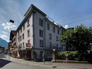 The façade of Alplodge Hostel, showing the traditional architecture and street view in Interlaken, Switzerland