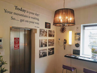 The interior of a hostel decorated with pictures and a quote on the wall