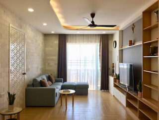 A living room with wooden floors and a ceiling fan.