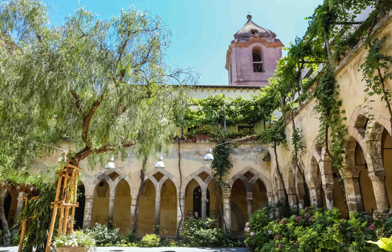 Inner courtyard of the Church and Convent of St. Francis in Sorrento, featuring arches, a weeping willow, and a bell tower partially obscured by foliage