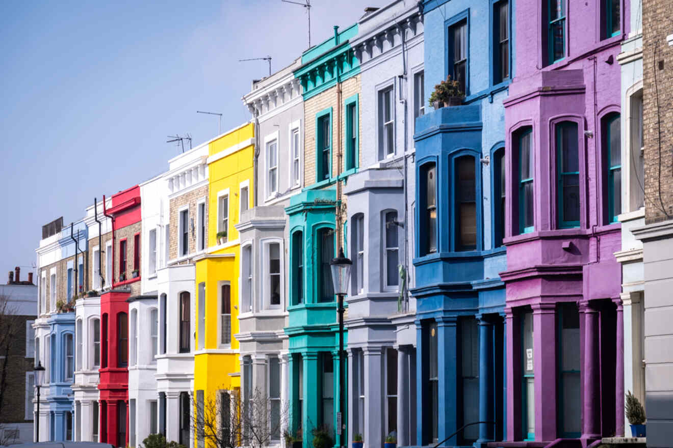Charming pastel-colored townhouses line a quiet street in the fashionable Notting Hill neighborhood of London