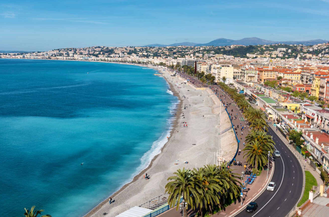 The famous Promenade des Anglais in Nice, France, with a sweeping view of the beachfront and azure Mediterranean waters, the bustling promenade lined with palm trees, and the cityscape in the distance