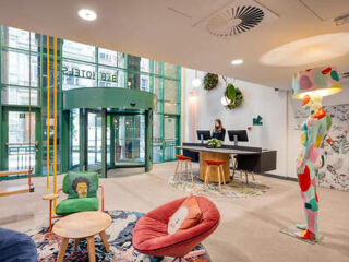 Colorful hotel entrance with playful furniture and artwork, creating an artistic and welcoming atmosphere