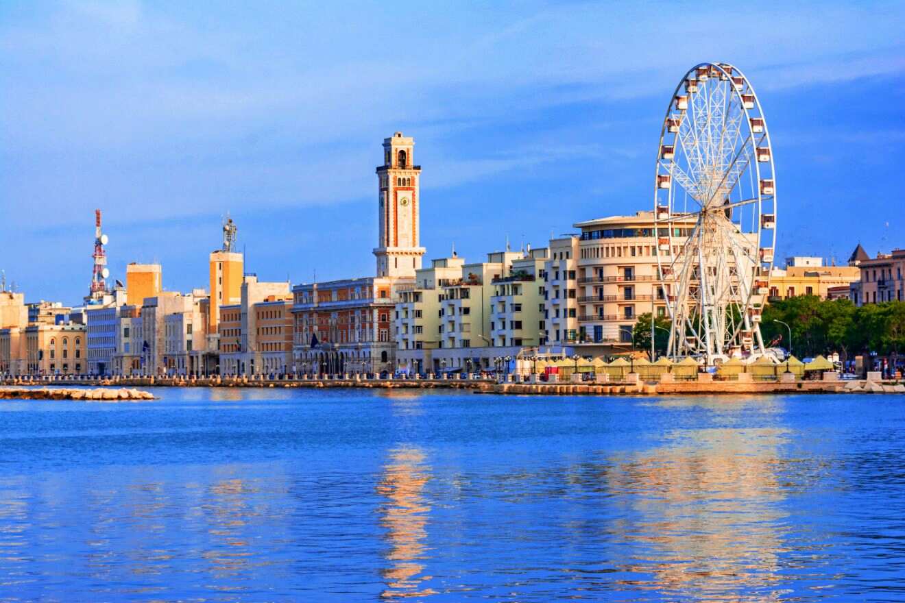 Scenic view of Bari's waterfront with a large Ferris wheel and historic buildings against a blue sky