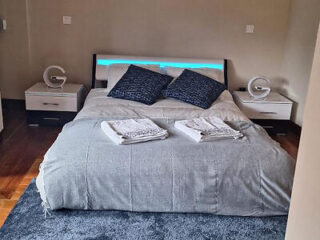 Contemporary bedroom in Porto with a backlit bed, sleek furnishings, and a cozy grey color scheme for a relaxing retreat