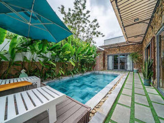 A swimming pool at a house with a wooden deck.
