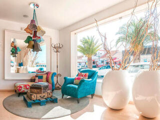 Eclectic lounge area with bold blue armchairs, quirky decorations, and large white vases