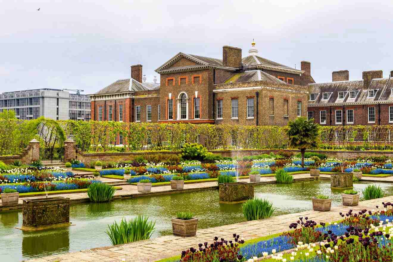 Kensington Palace surrounded by meticulously maintained gardens with colorful flower beds and a tranquil pond in the foreground