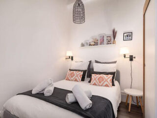 A stylish bedroom with chic black and white bedding, pendant lighting, and tasteful decor