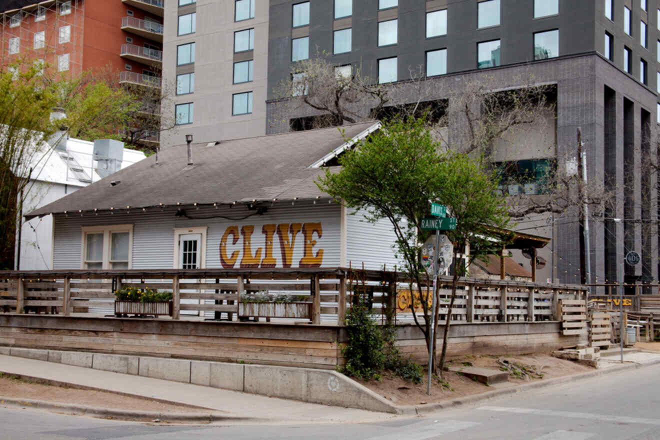 A small wooden building on the side of a street where the bar Clive is located, in the Rainey Street Historic District in Austin, Texas