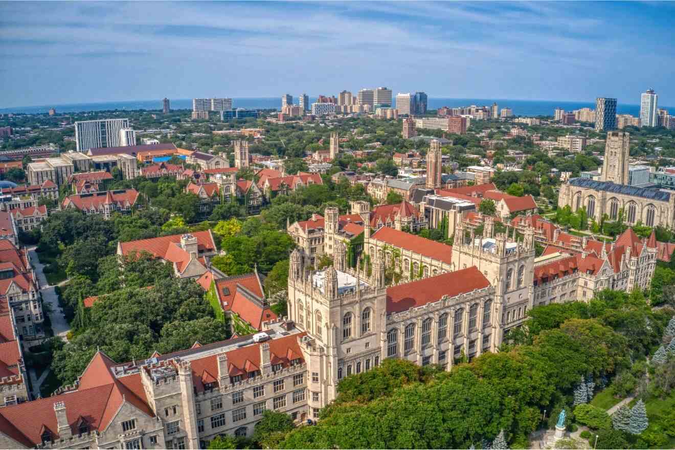 Aerial view of the University of Chicago campus with its Gothic architecture, lush greenery, and Lake Michigan in the distance