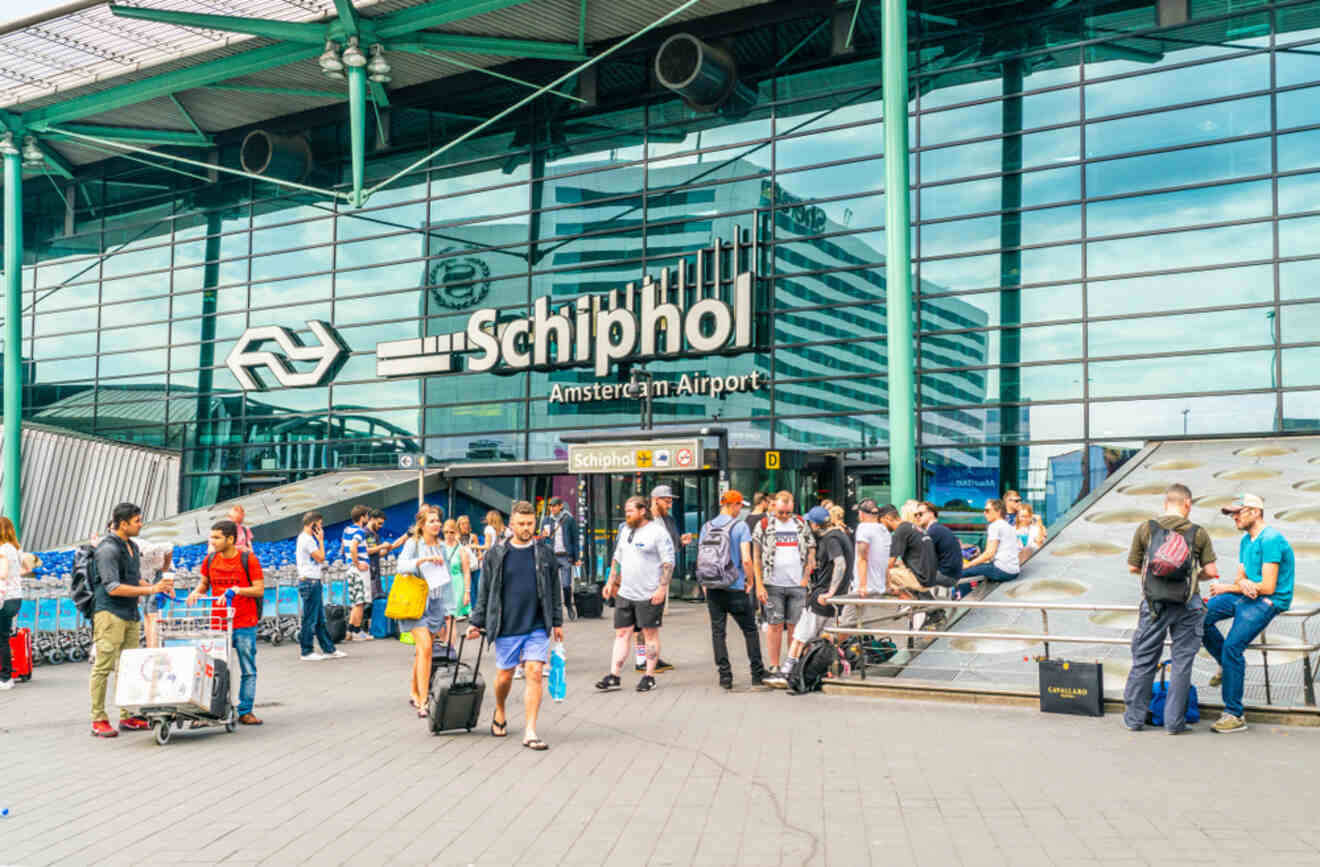 Busy scene outside Amsterdam Schiphol Airport with travelers and signage.