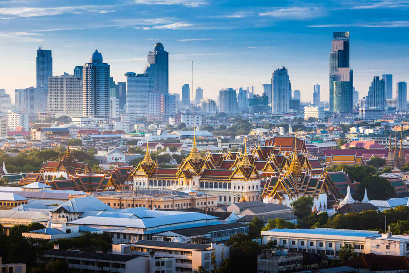 Panoramic view of Bangkok skyline at sunrise, highlighting the contrast between traditional Thai architecture of the Grand Palace and modern skyscrapers.