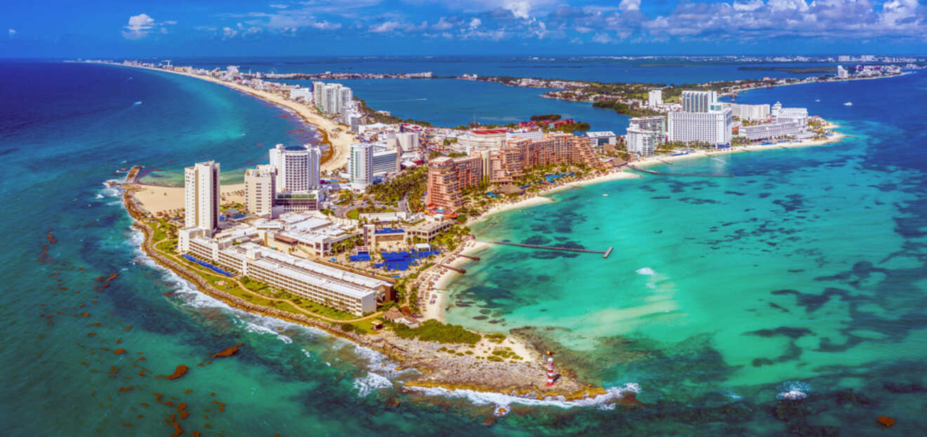 Aerial perspective of Cancun's Hotel Zone, showcasing a narrow strip of land with resorts flanked by the sapphire blue ocean on one side and the tranquil Nichupté Lagoon on the other
