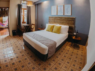 Cozy hotel room with a comfortable queen-sized bed, tiled floor, and wooden furniture