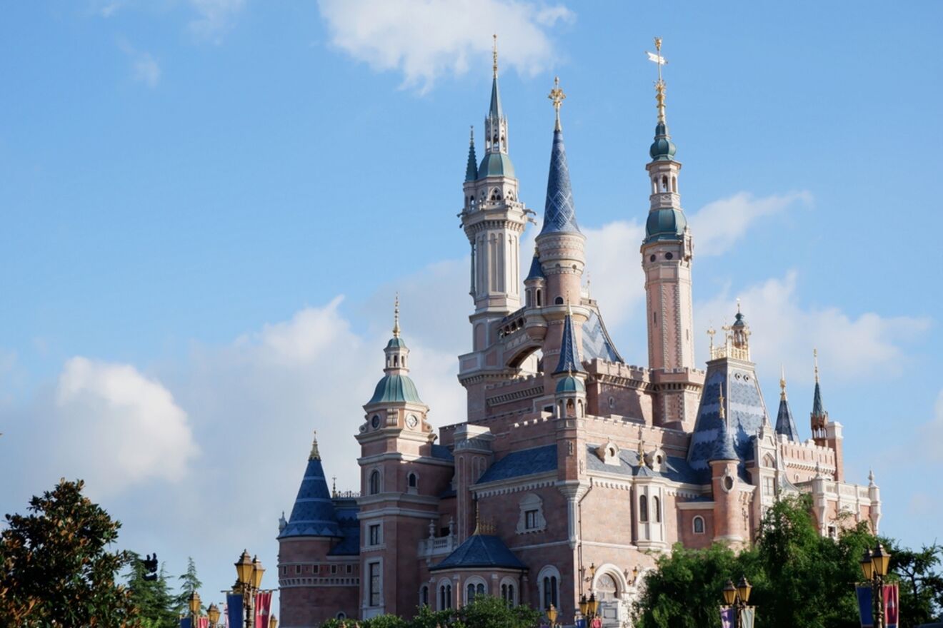 The fairytale-inspired castle at Disneyland Shanghai against a backdrop of blue skies, with flags and turrets reaching upwards