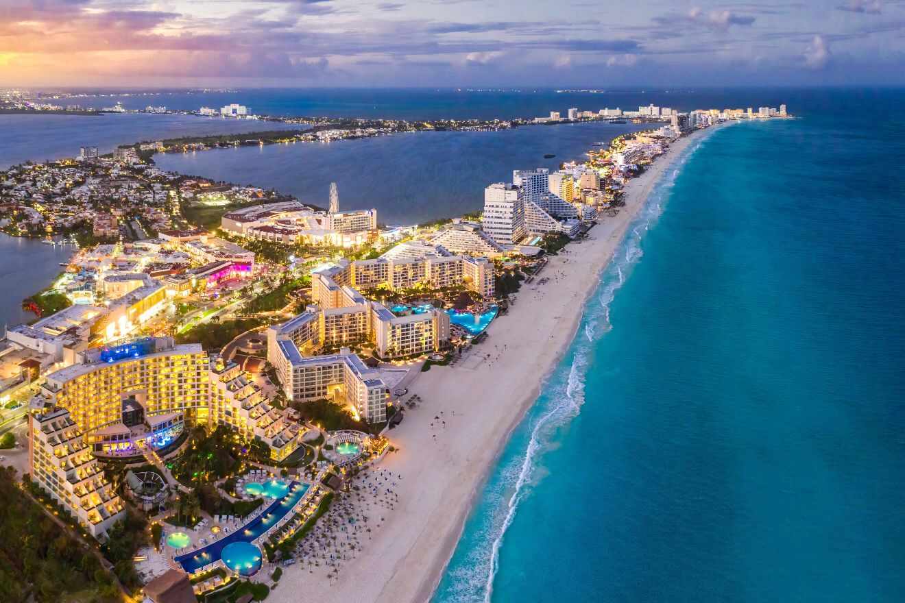 Twilight descends on Cancun's Hotel Zone, illuminating the resort-lined beach that stretches towards the horizon along the glistening turquoise waters of the Caribbean Sea