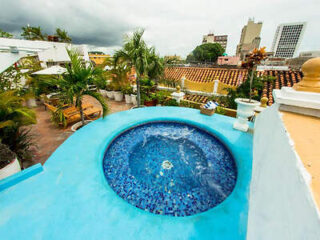 Vibrant rooftop jacuzzi area with a mosaic-tiled hot tub and city views
