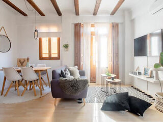 Bright and airy living space with modern furnishings and original wood beam ceiling
