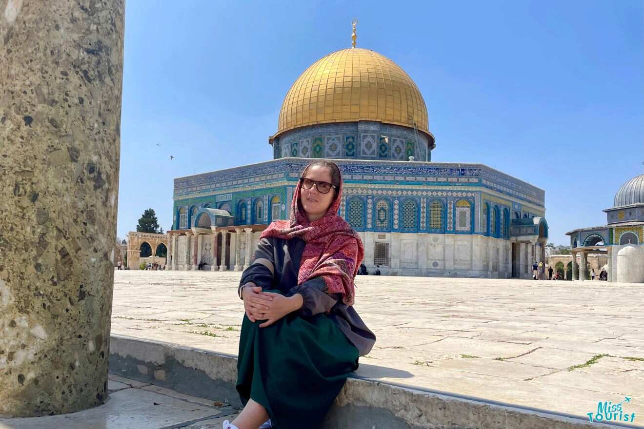 The writer of this post, Darija, seated in front of the Dome of the Rock, wearing a headscarf, with the iconic golden dome and blue tile work in the background.