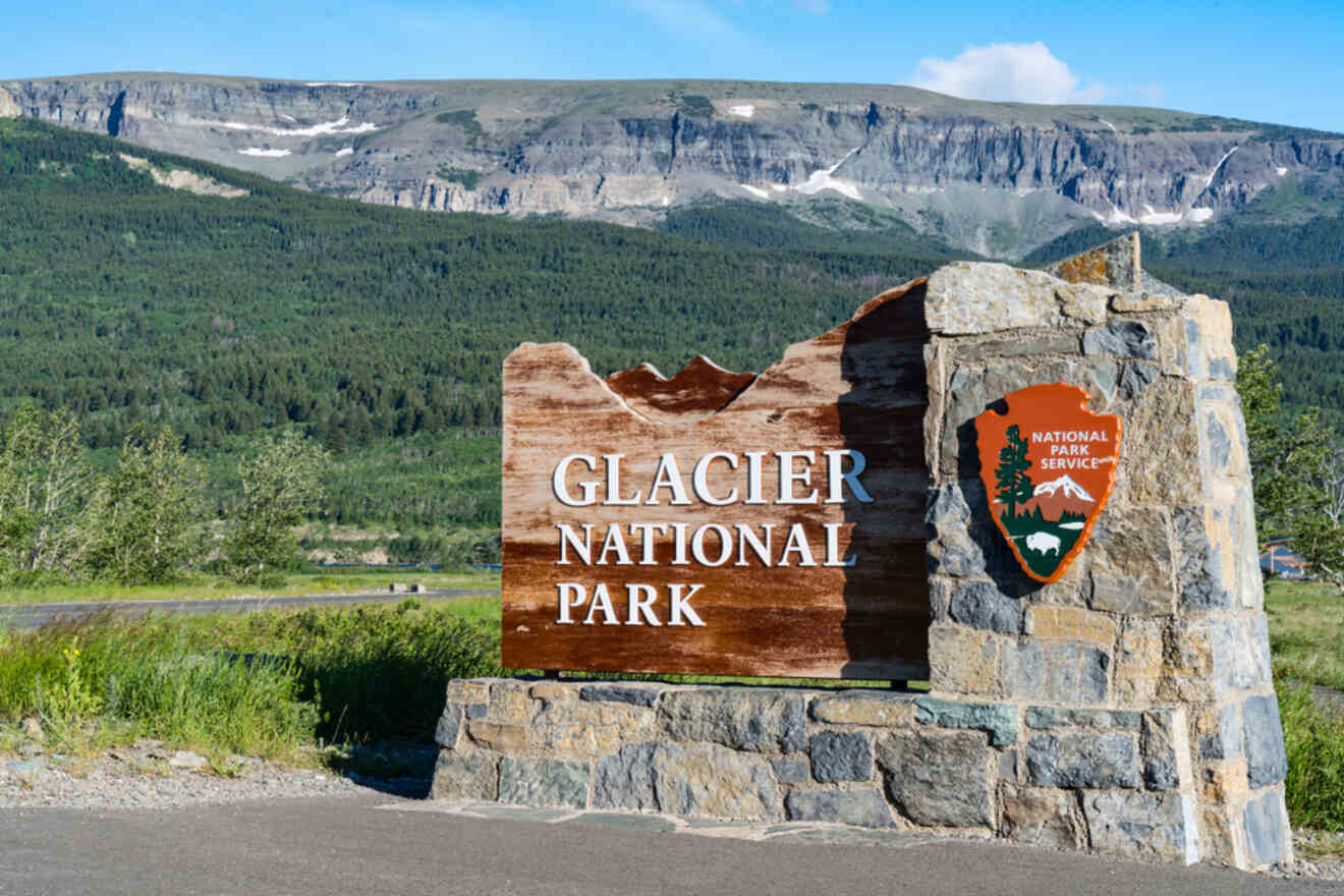 Welcome sign for Glacier National Park with a brown wooden backdrop and the National Park Service emblem, set against a mountainous landscape