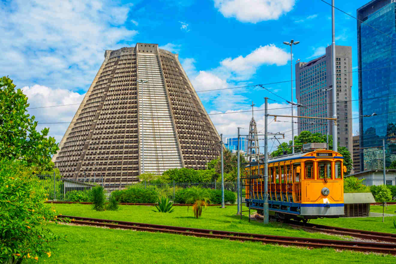 The unique cone-shaped Cathedral of Rio de Janeiro with a traditional tram in front, surrounded by modern skyscrapers
