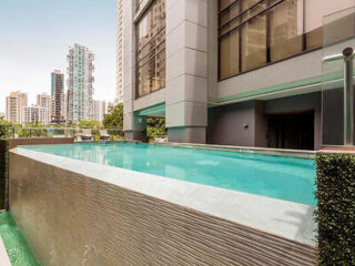 Modern infinity pool at Aloft Panama, bordered by stylish outdoor furniture and high-rise buildings in the backdrop