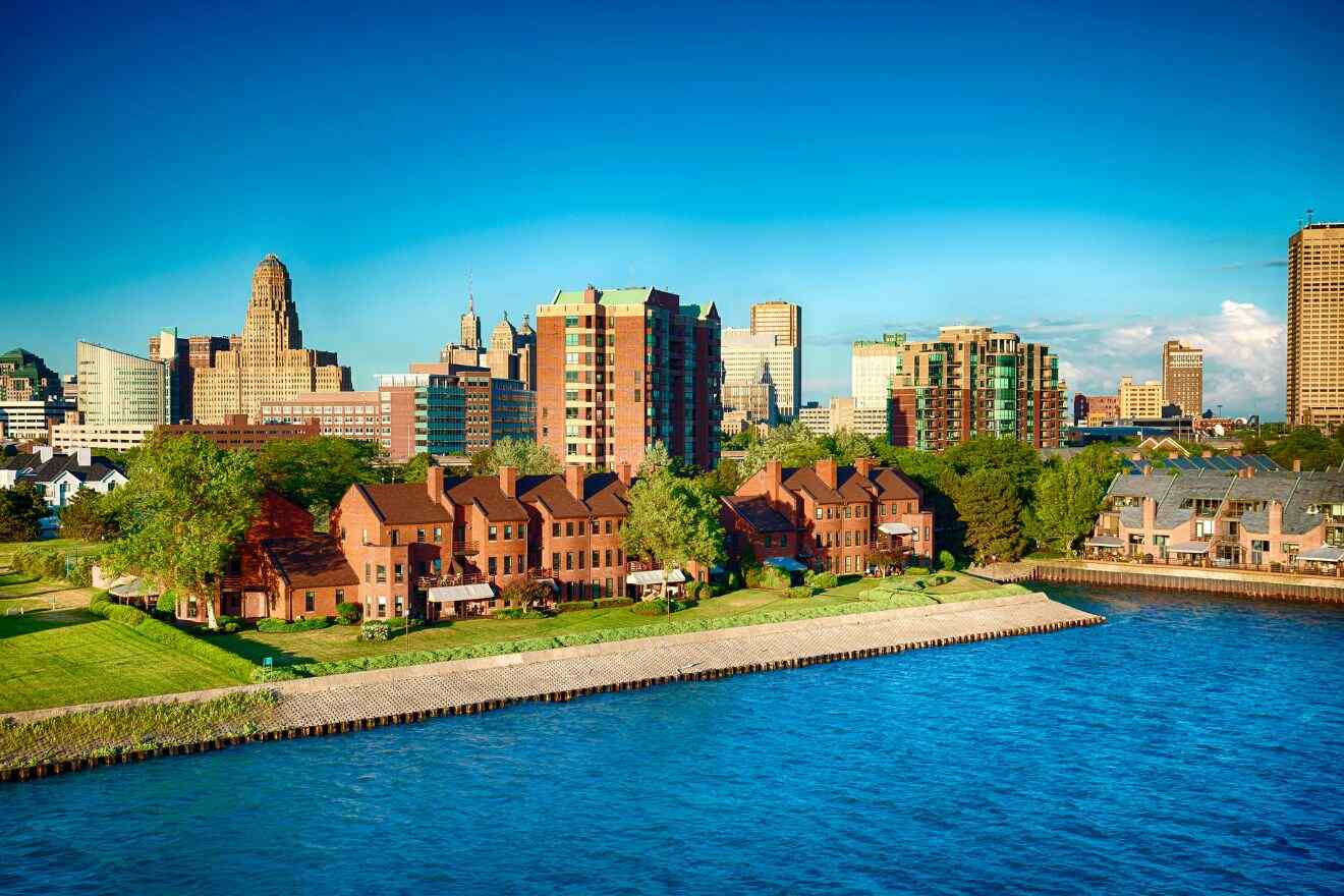Panoramic skyline of Buffalo, New York, showcasing modern high-rise buildings and traditional architecture near the waterfront under a bright blue sky