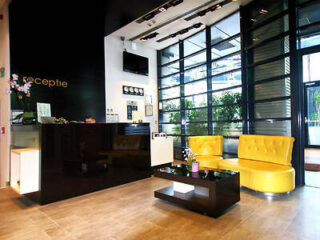 A hotel lobby with bright yellow seating, modern decor, and a welcoming reception area