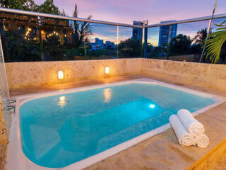 Private outdoor hot tub on a balcony with romantic lighting and city views