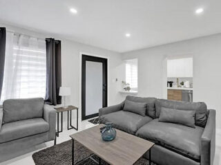 Chic 2-bedroom apartment with a grey sofa set, minimalist decor, and natural light