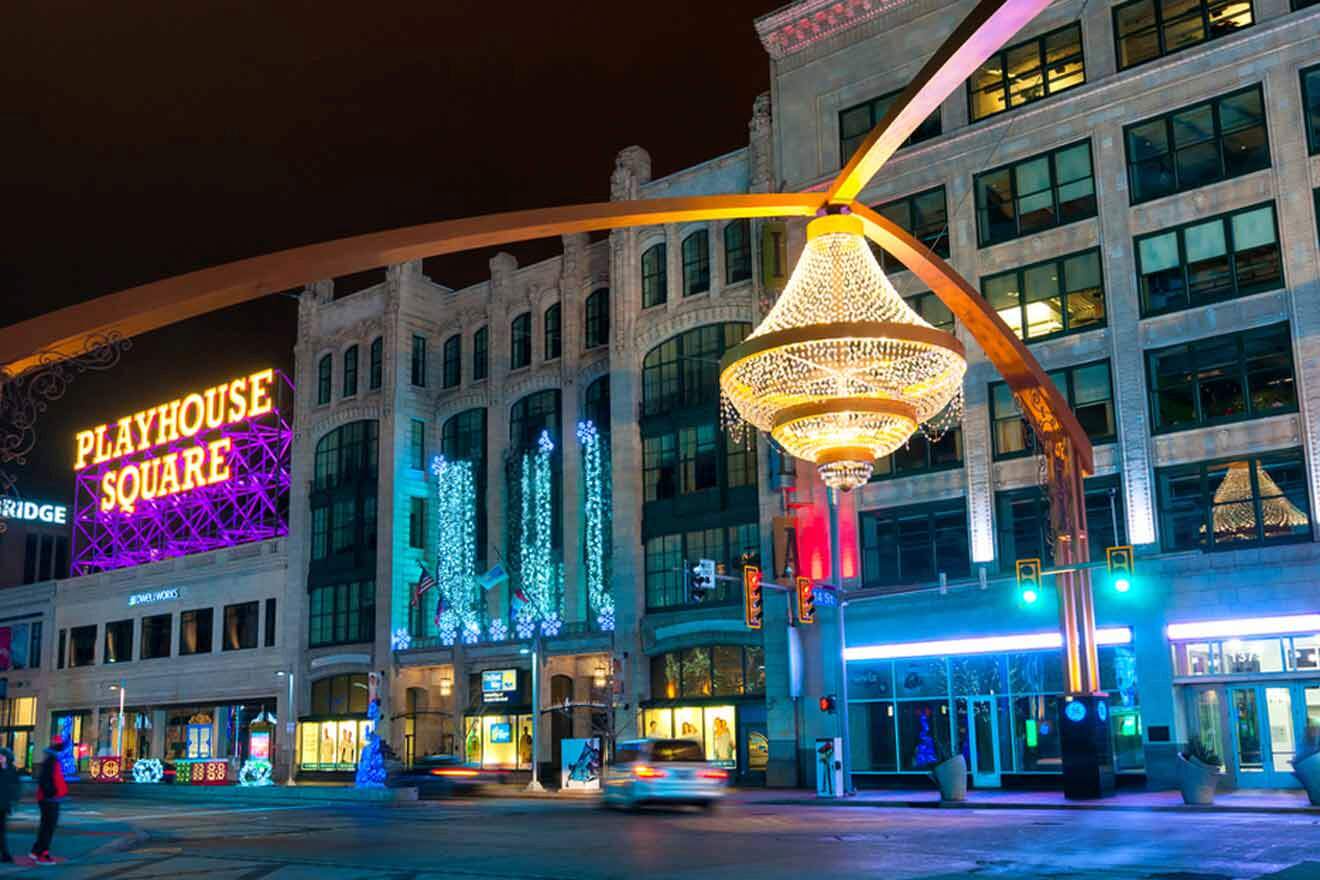 The Playhouse Square district in Cleveland at night, featuring vibrant neon signage and the iconic outdoor chandelier.
