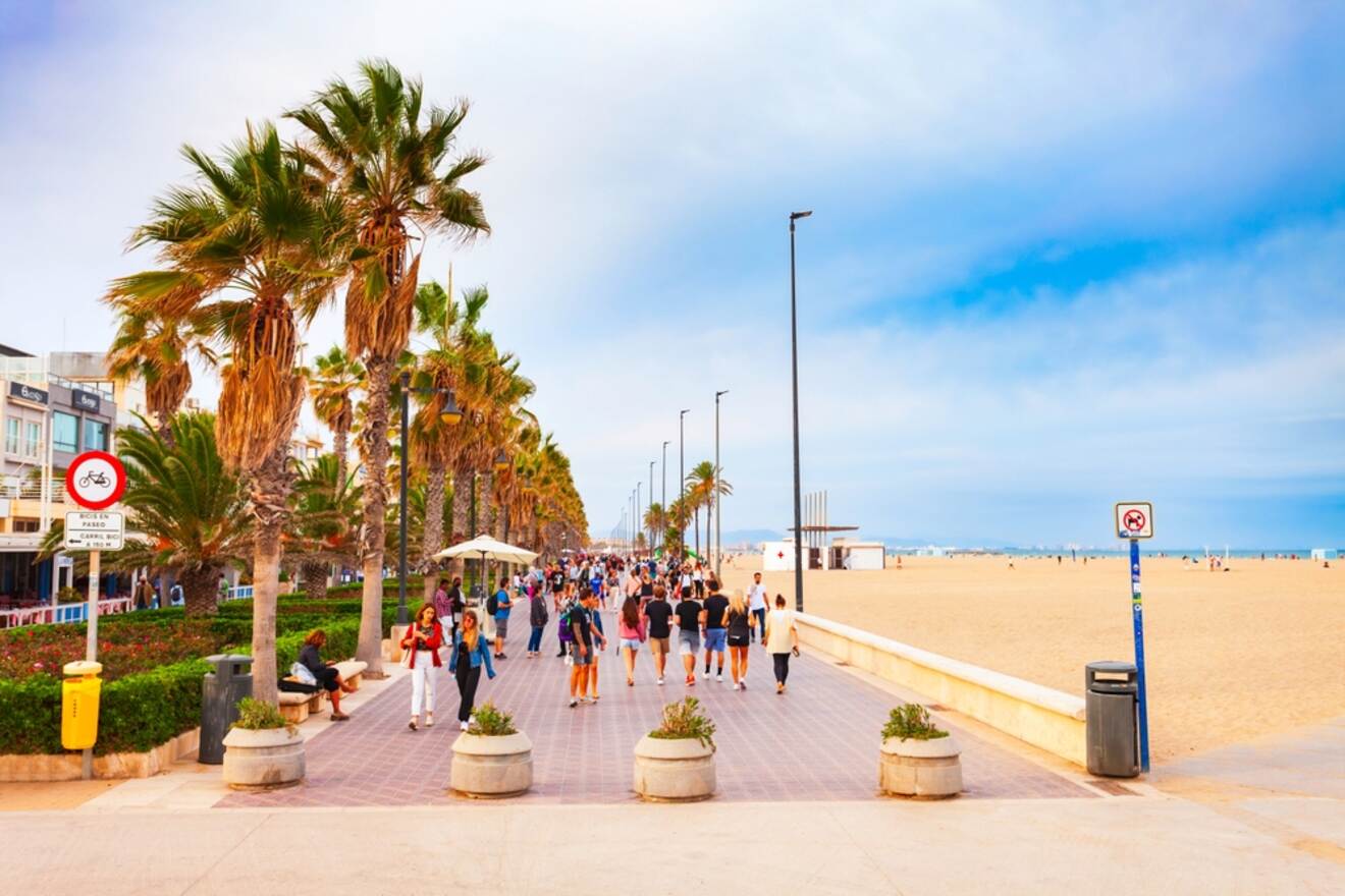 Vibrant scene of El Cabanyal & Malvarrosa beach promenade with palm trees and pedestrians in Valencia