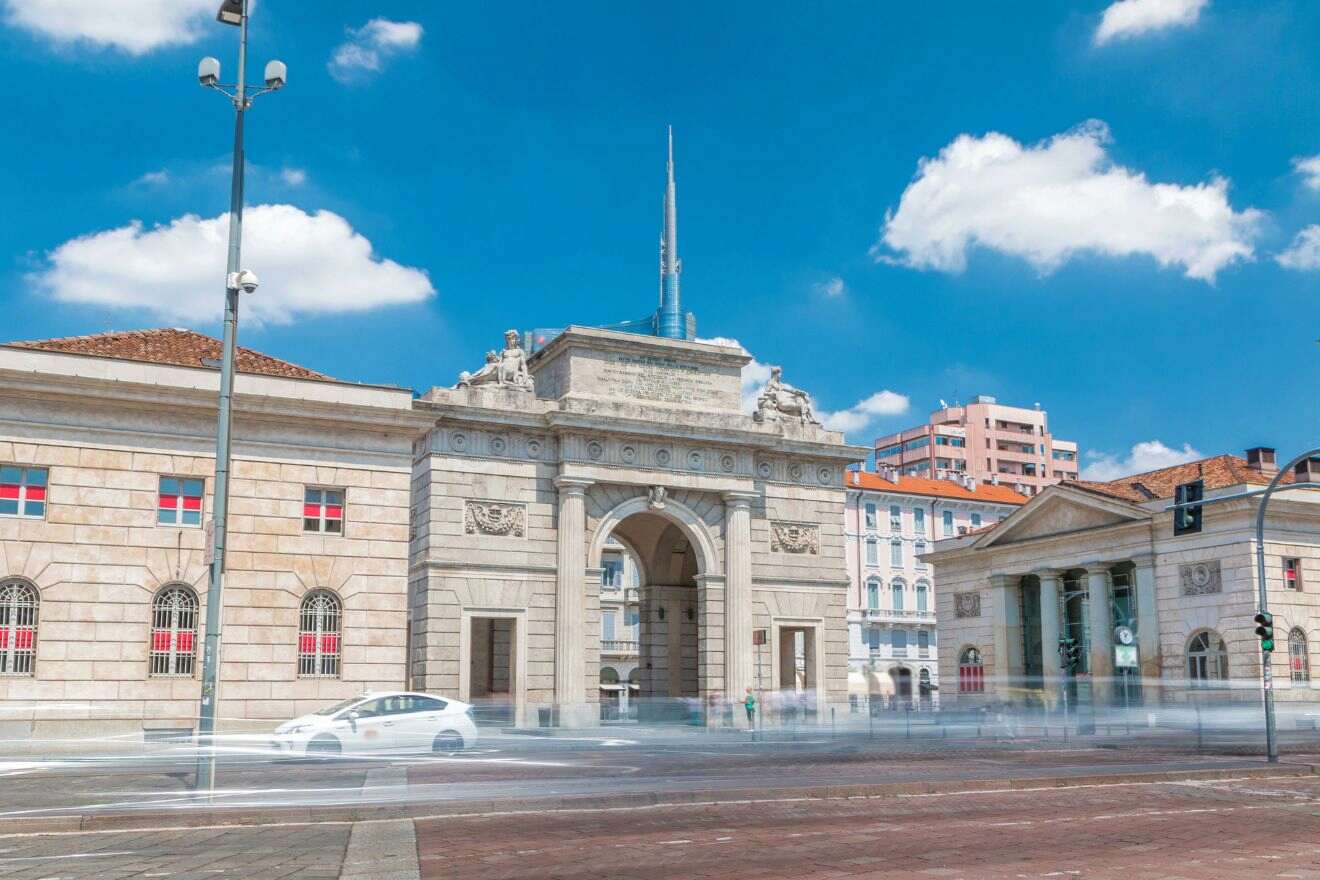 The historic Porta Garibaldi facade, captured in daylight with blurred motion of people and vehicles