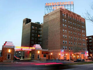Ambassador Hotel exterior at twilight with its iconic neon sign and historic architecture