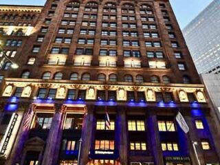 A historical building in downtown Cleveland lit with blue lights at dusk, highlighting the city's architectural heritage.