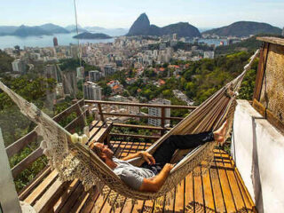 Relaxing hammock on a balcony with a breathtaking panoramic view of Rio de Janeiro's cityscape and mountains