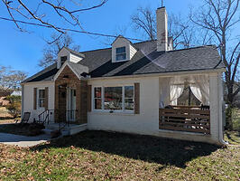 Charming bungalow with a welcoming front porch, nestled in a residential area
