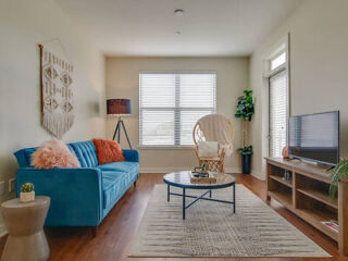 Bright and airy living space with a vibrant blue sofa, woven wall hanging, and minimalist decor